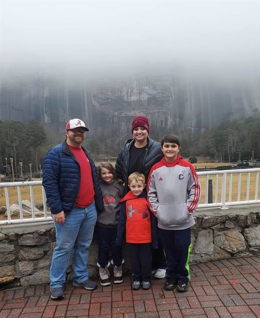 Patrick smiles to camera with his wife and three sons.